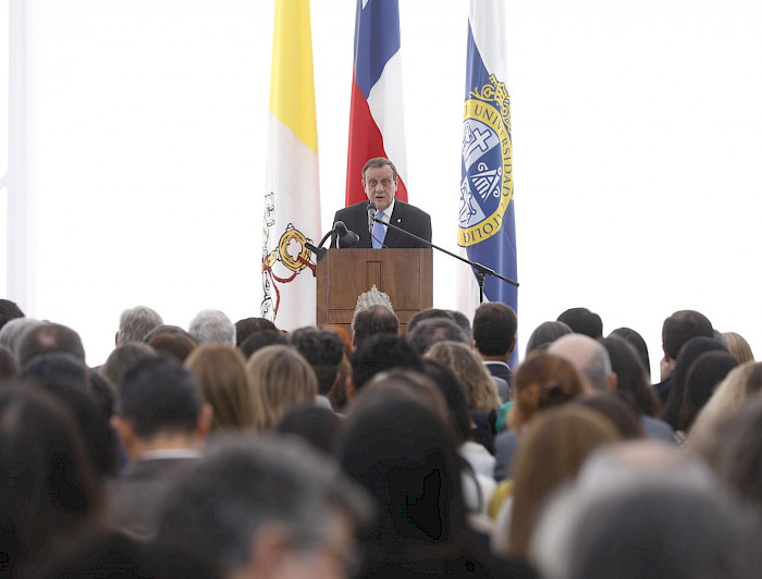 Rector UC Ignacio Sánchez hablando desde un podio a la comunidad UC.