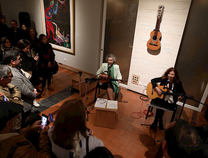 Dos mujeres cantando y tocando guitarra en la Casa Violeta Parra. Créditos: Karina Fuenzalida.