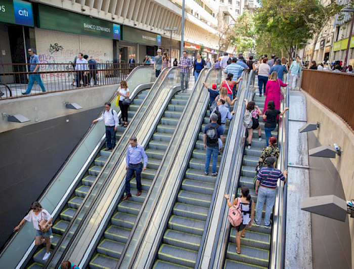 Personas usando una escalera eléctrica del Metro de Santiago.
